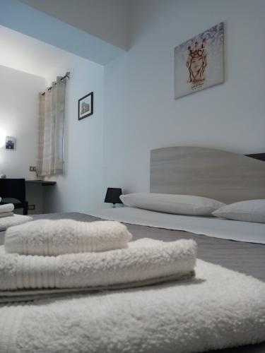 1 dormitorio con 2 camas y toallas blancas en el suelo en Momenti e Monumenti en Palermo