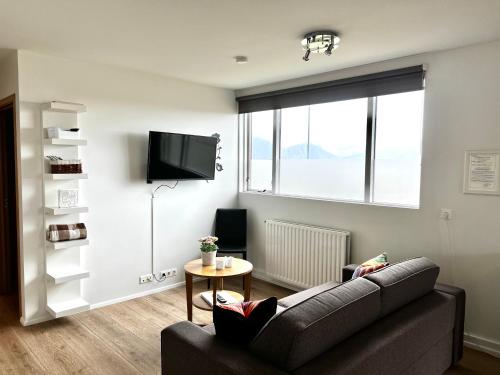 Lónið Apartments في هوفن: غرفة معيشة مع أريكة وطاولة