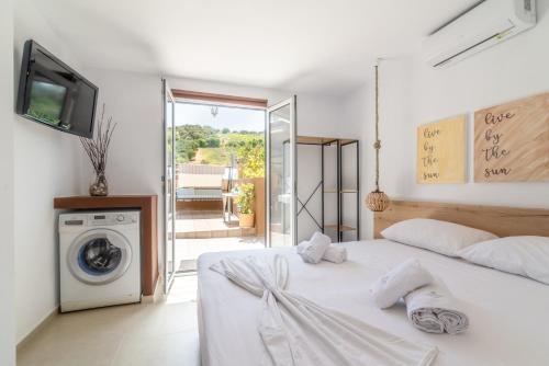 um quarto com uma cama branca e uma máquina de lavar roupa em Countryhouse Villa with pool & private parking em Heraclião