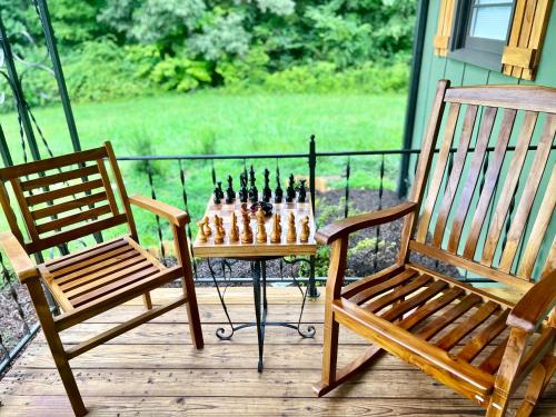 a chess board on a table and a bench on a porch at Misty Mountain Cabin in Franklin