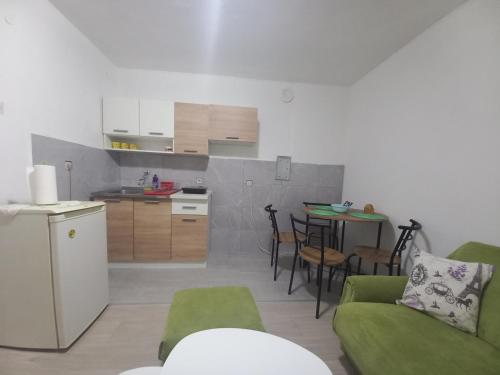 Bileća的住宿－Apartman Vera，厨房以及带沙发和桌子的客厅。