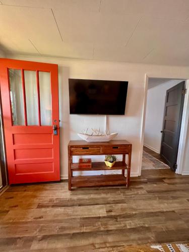 a living room with a red door and a tv at Misty Mountain Cabin in Franklin