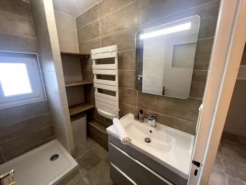 une salle de bain avec un lavabo, un miroir et une baignoire dans l'établissement Bon séjour - Appartement 3 chambres, à Chalon-sur-Saône