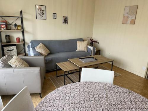 un salon avec un canapé et une table dans l'établissement Bon séjour - Appartement 3 chambres, à Chalon-sur-Saône