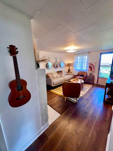 a living room with a guitar hanging on the wall at Misty Mountain Cabin in Franklin