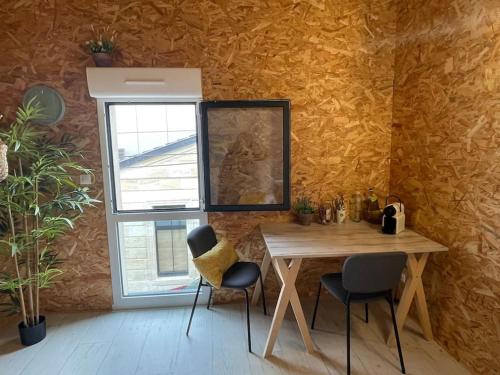 a table and chairs in a room with a cat sitting on the wall at Studio Cosy Mezzanine in Talence