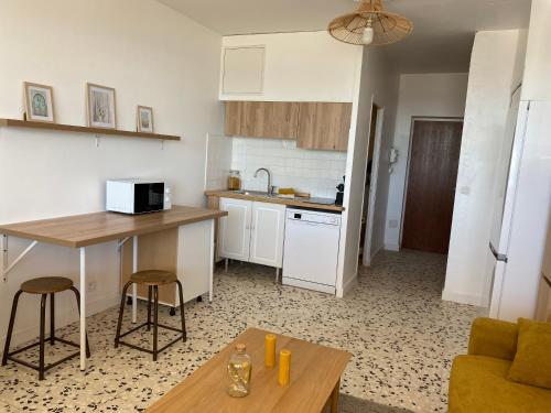 une cuisine avec une table et un comptoir dans l'établissement Studio Mer Les 3 Trésors, au Grau-dʼAgde