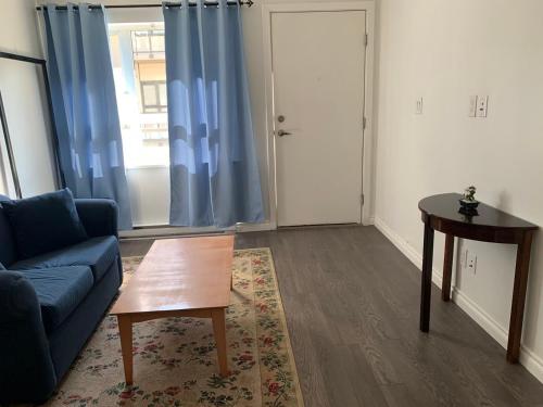 a living room with a blue couch and a table at Best Choice Apartment in Vancouver