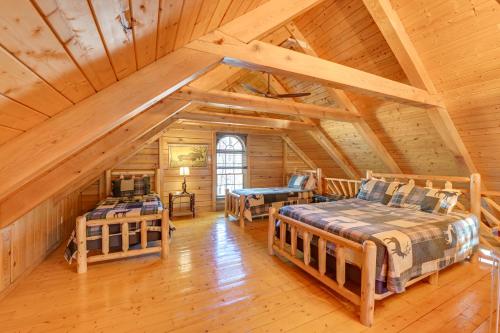 1 dormitorio con 2 camas en una cabaña de madera en Exquisite Cabin with Deck and Fire Pit, 10 Mi to Lake, en Athol