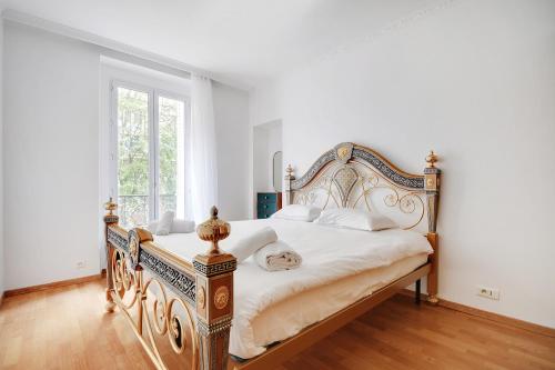 - une chambre blanche avec un grand lit et des draps blancs dans l'établissement Vivez au coeur du centre de Paris! Métro à 1min - Proche Republique, à Paris