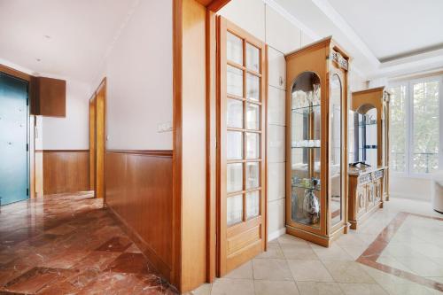 un grand couloir avec des portes en bois et des panneaux de verre dans l'établissement Vivez au coeur du centre de Paris! Métro à 1min - Proche Republique, à Paris