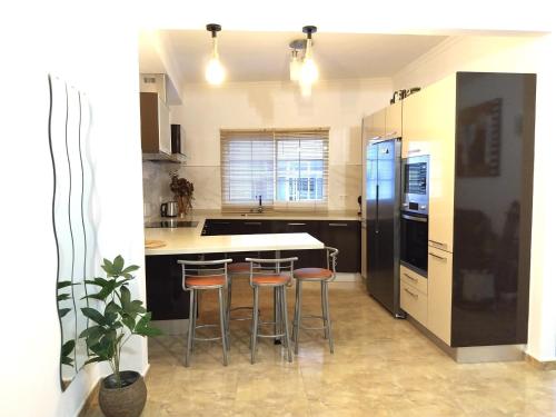a kitchen with a counter and stools in it at Roque's House in Telde