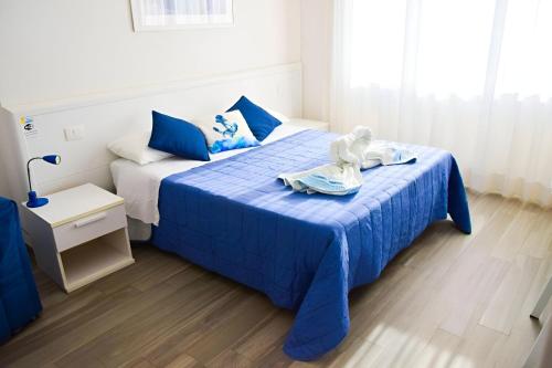 Un dormitorio con una cama azul con una toalla. en La Marina B&B, en Civitavecchia