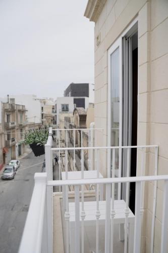 a balcony with a white railing and a view of a street at Your Modern Comfort Home in Malta in Mosta