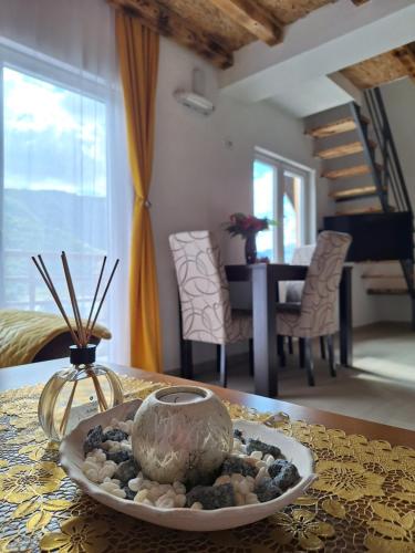a table with a bowl of rocks on a table at Apartmani Lena in Pluzine