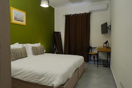 a bedroom with a bed and a green wall at Your Modern Comfort Home in Malta in Mosta