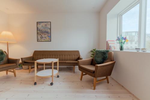 a waiting room with couches and a table and chairs at Charming Central Tórshavn Retreat - 2BR Apartment in Tórshavn