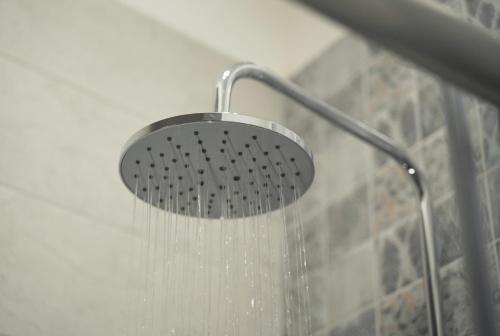 a shower with a shower head with water coming out at Modern 5-Bedroom Apartment Central Malta in Mosta