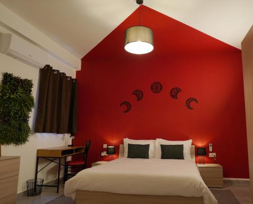 a bedroom with a red wall with a bed at Modern 5-Bedroom Apartment Central Malta in Mosta