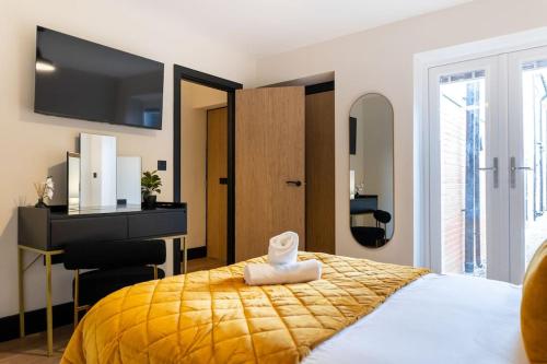 a bedroom with a yellow bed with a desk and a desk at The Berriman Collection Stylish 2 Bedroom Apartment in Cardiff