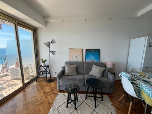 un salon avec un canapé et une grande fenêtre dans l'établissement Sea View and Promenade, à Nice