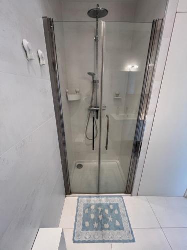 d'une douche avec une porte en verre et un tapis de douche. dans l'établissement Sea View and Promenade, à Nice