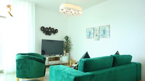a living room with a green couch and a tv at Modern 1BR Stay - Sleek Chic Cozy Haven in Abu Dhabi