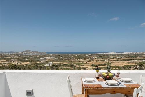 a table with chairs and a view of a field at Villa Lagkadia in Glinádhon