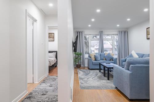 a living room with two blue couches and a table at Littlewood Properties in Toronto