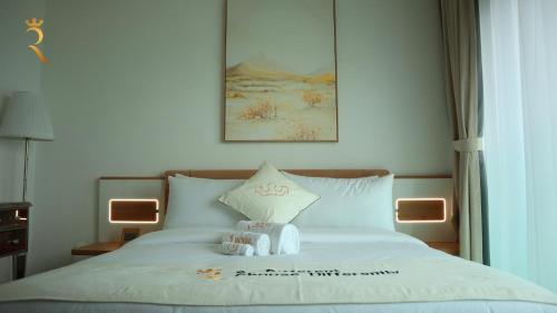 a bed with two stuffed animals on top of it at Modern 1BR Stay - Sleek Chic Cozy Haven in Abu Dhabi