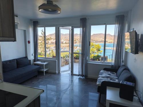 uma sala de estar com um sofá e uma grande janela em El Faro seacave em Puerto de Mazarrón