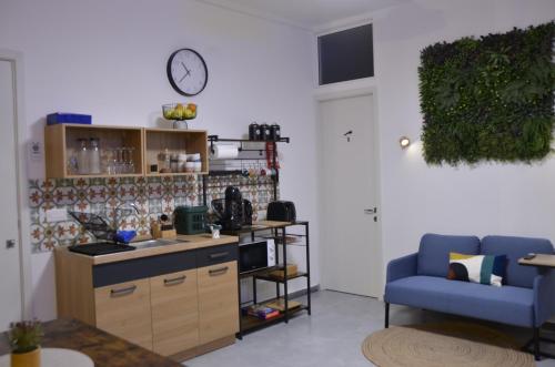 a kitchen with a blue couch and a clock on the wall at Your Modern Comfort Home in Malta in Mosta