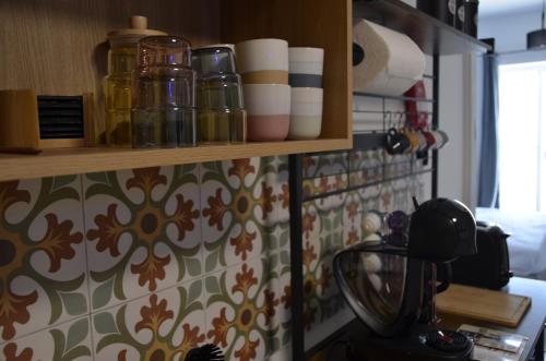 a kitchen with a shelf with jars on a wall at Your Modern Comfort Home in Malta in Mosta