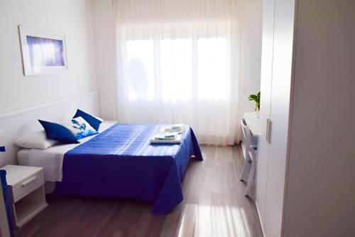 a bedroom with a blue bed and a window at La Marina B&B in Civitavecchia