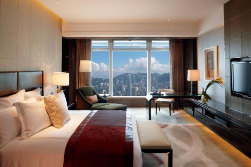 a hotel room with a bed and a large window at The Ritz-Carlton Hong Kong in Hong Kong