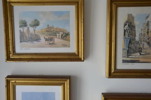 a couple of framed pictures hanging on a wall at Your Modern Comfort Home in Malta in Mosta