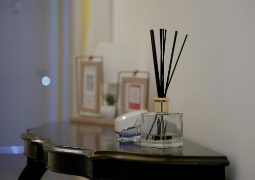 a glass vase with sticks in it on a table at Your Modern Comfort Home in Malta in Mosta
