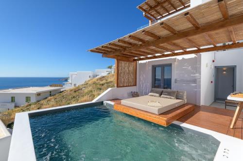 Villa con piscina y terraza con cama en Oneiro Luxury Suites-Adults Only, en Astipalea