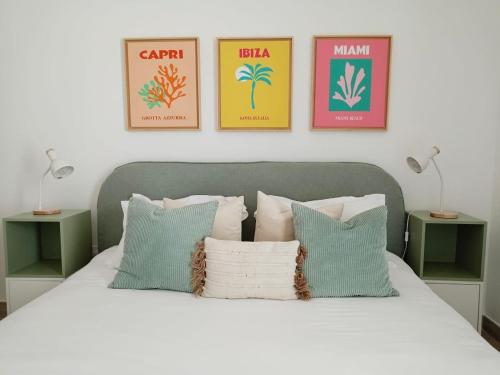 1 dormitorio con 1 cama blanca y 4 cuadros en la pared en Yas Island canal 2- where luxury meets comfort next to Formula 1 en Abu Dabi