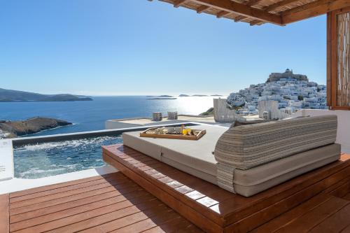 Oneiro Luxury Suites-Adults Only في مدينة أستيباليا: سرير على سطح مطل على المحيط