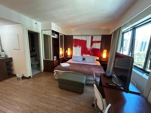 a hotel room with a bed and a television at Apartamento em Hotel 4 estrelas - Moema in Sao Paulo