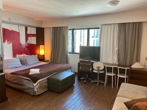 a hotel room with a bed and a desk with a computer at Apartamento em Hotel 4 estrelas - Moema in Sao Paulo