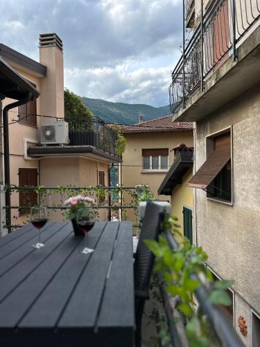 two glasses of wine on a wooden table on a balcony at Timco apartment with big terrace, partial lake view and air-conditioner in Torno