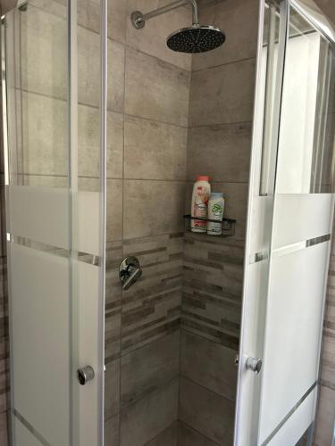 a shower with a glass door in a bathroom at Timco apartment with big terrace, partial lake view and air-conditioner in Torno