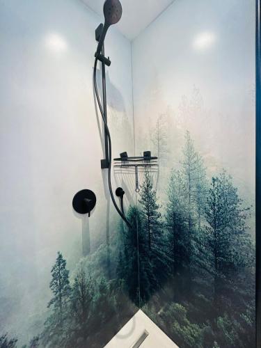 eine Dusche mit einem Bild eines Waldes in der Unterkunft Tiny House Wettelsheim in Treuchtlingen