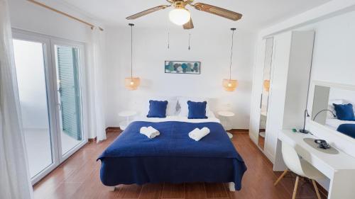 a bedroom with a blue bed with two pillows at Apartments Antonio in Tisno