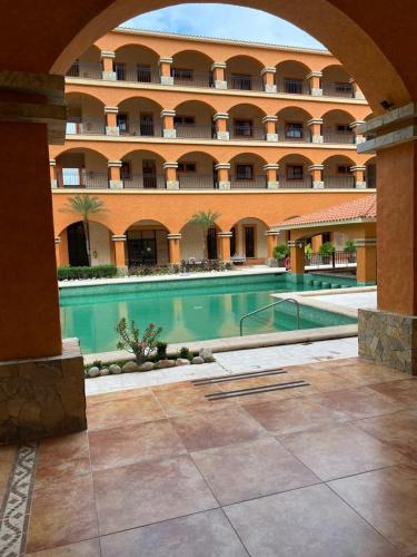 un grand bâtiment avec une piscine dans une cour dans l'établissement Marina Park Plaza, à Santa Cruz Huatulco