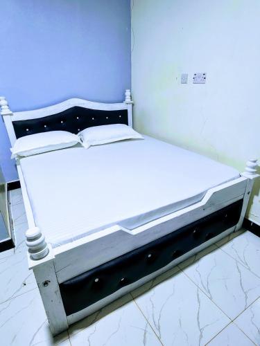 Bett in einem Zimmer mit einer weißen Matratze in der Unterkunft Swift Haven Stays in Chuka