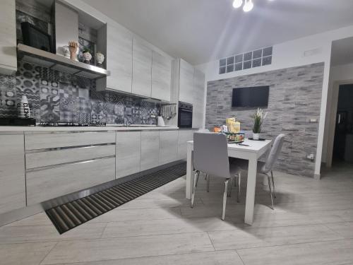 a kitchen with a table and chairs and a tv at Home Santa Chiara Marigliano in Marigliano