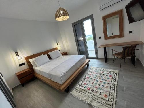 1 dormitorio con 1 cama grande y 1 alfombra en Filia Skyros Suites, en Skiros